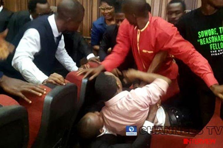 Publisher of Sahara Reporters, Omoyele Sowore, in a peach shirt being forcibly dragged down by a DSS officer in the court during his rearrest by the DSS on December 7 / Photo credit: Channels TV